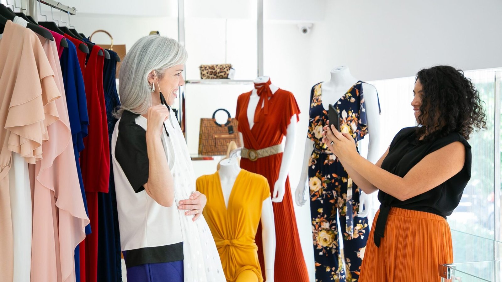Happy ladies enjoying shopping in fashion store together